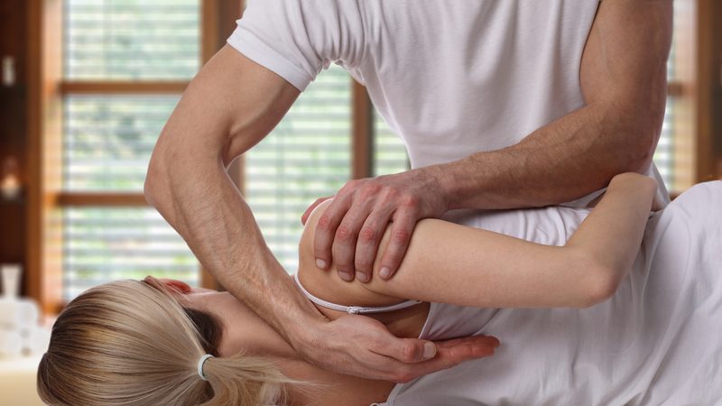 A chiropractor performing a hands-on back adjustment
